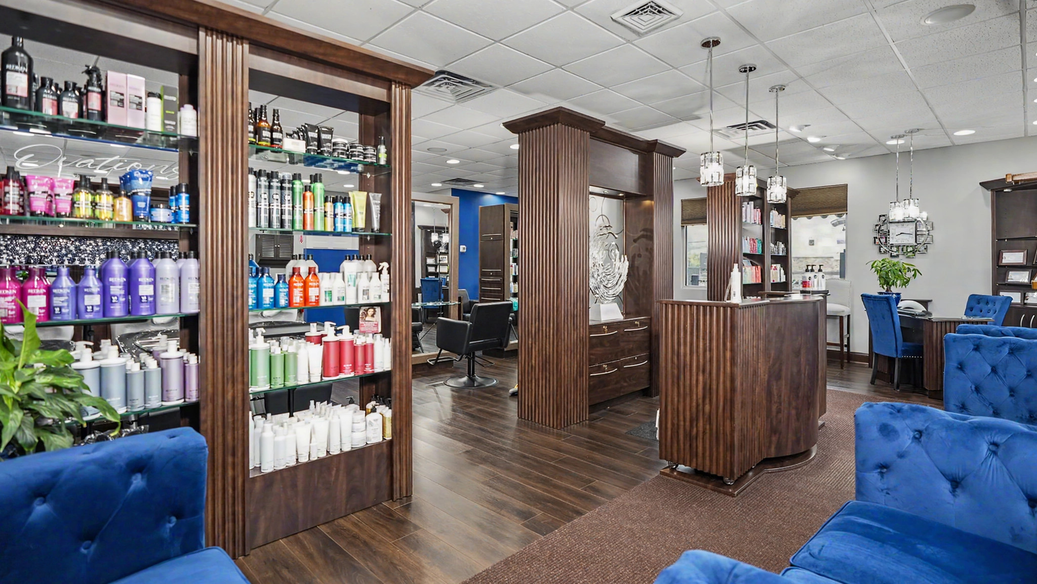 The Ovations reception area with a curved wooden desk, product shelves and blue seating